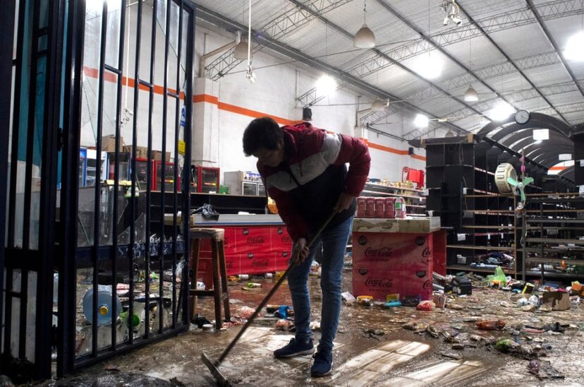 Comerciante limpia después de los saqueos.